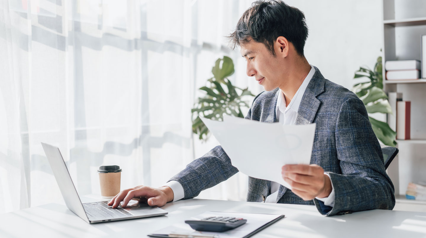 Deux professionnels (conseiller en énergie et responsable d'entreprise) en réunion de travail collaborative dans bureau moderne français, examinant ensemble documents contractuels énergétiques et tableaux de consommation sur ordinateur