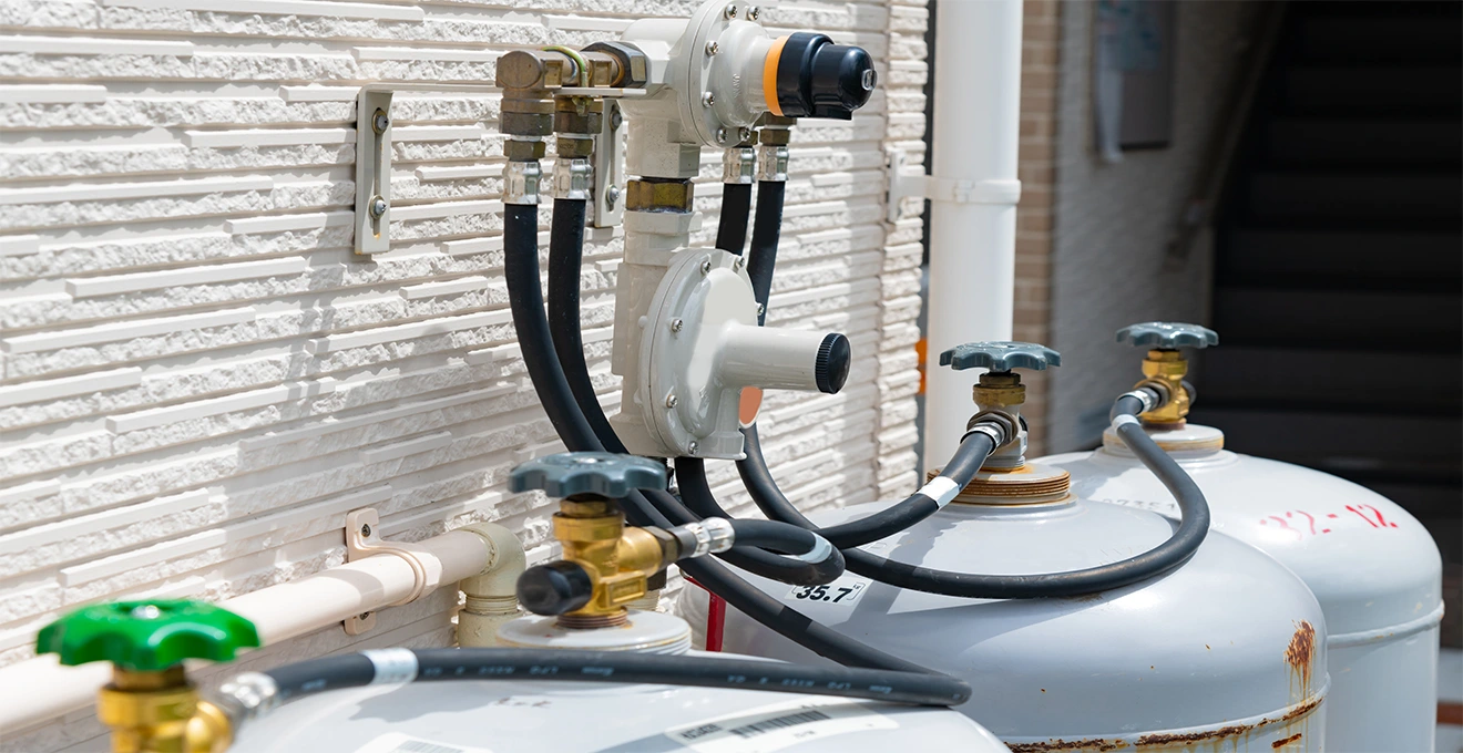Un technicien gaz inspecte une vanne du réseau de distribution dans une rue résidentielle.